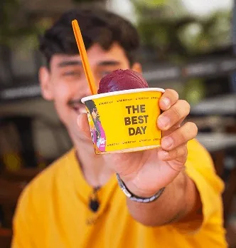 Cliente segurando copo The Best Day